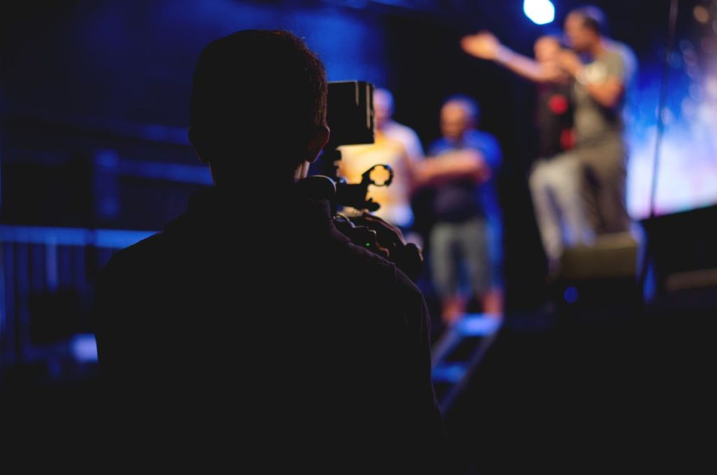 Cameraman filming a live stage performance for a highlight video