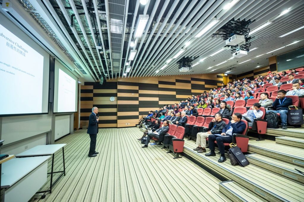 Speaker presenting to an in-person audience during a hybrid livestreamed event