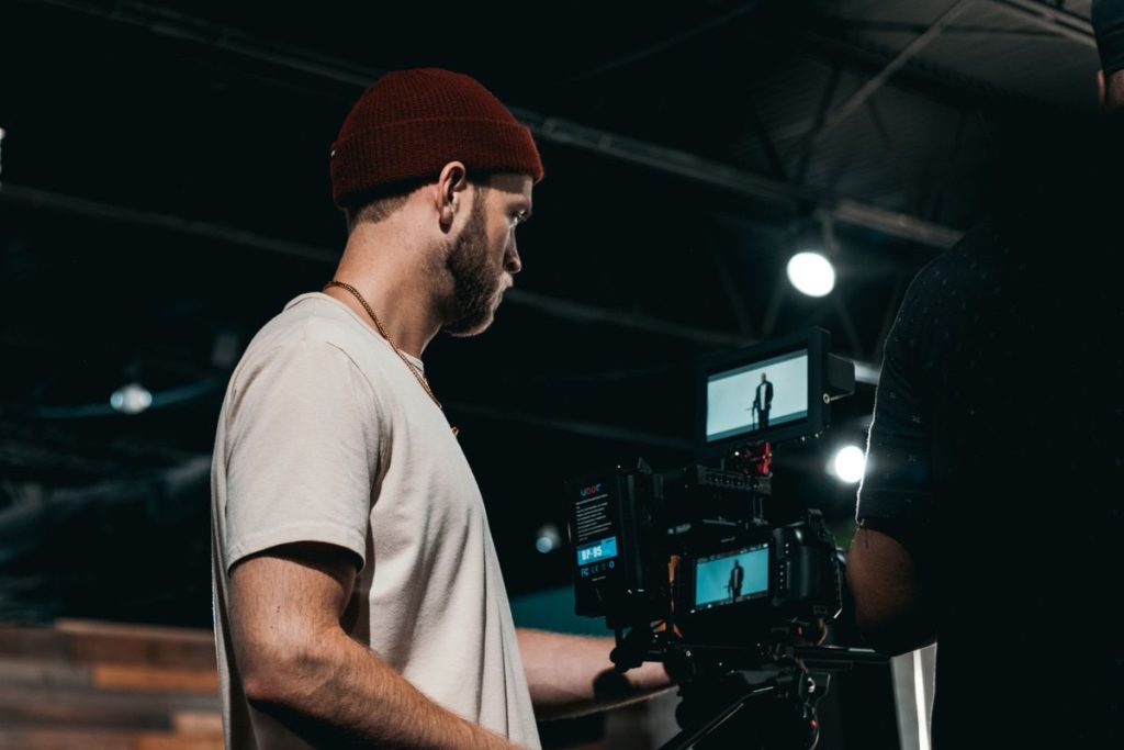 Professional videographer operating a camera indoors for a corporate video shoot